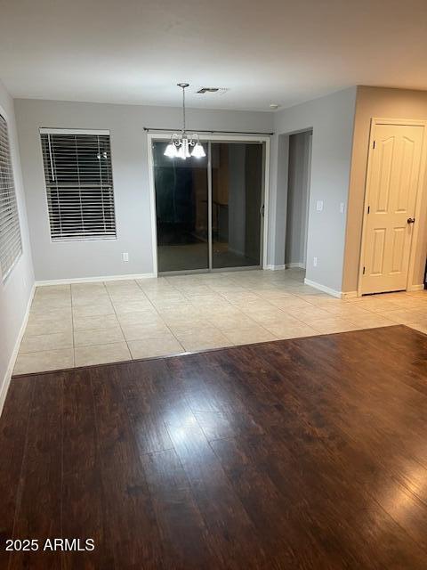 unfurnished room with an inviting chandelier and light hardwood / wood-style floors