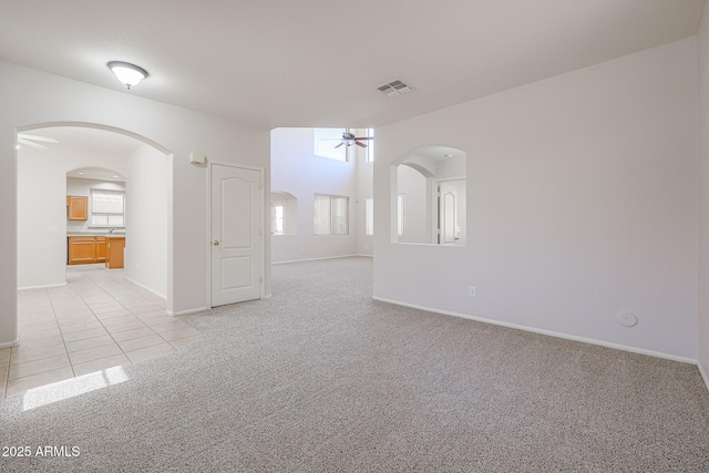 spare room featuring ceiling fan and light carpet