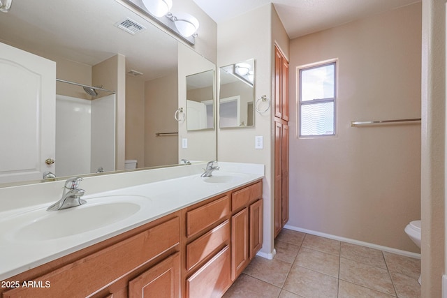 bathroom with tile patterned flooring, vanity, and toilet