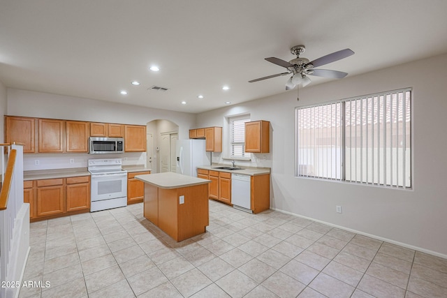 kitchen with ceiling fan, a center island, light tile patterned floors, and white appliances