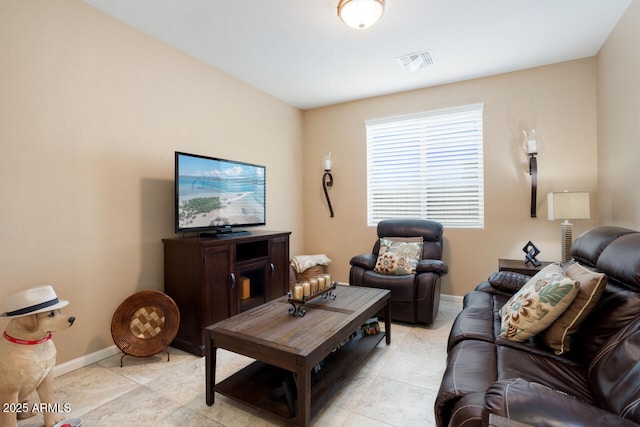 living area with light tile patterned floors, visible vents, and baseboards