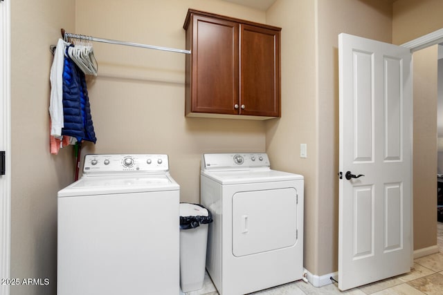 washroom with cabinet space, independent washer and dryer, and baseboards