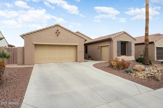 mediterranean / spanish-style house featuring stucco siding, driveway, an attached garage, and a tile roof