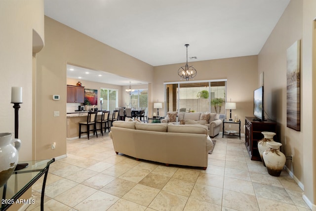 living area featuring light tile patterned floors, baseboards, and an inviting chandelier