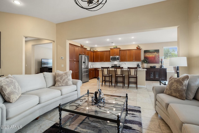 living room featuring light tile patterned floors, recessed lighting, and arched walkways