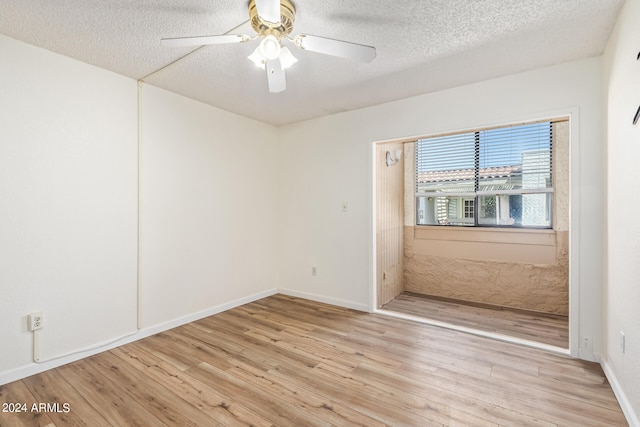 unfurnished room featuring a textured ceiling, light wood-type flooring, and ceiling fan