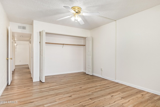 unfurnished bedroom featuring a textured ceiling, a closet, light wood-type flooring, and ceiling fan