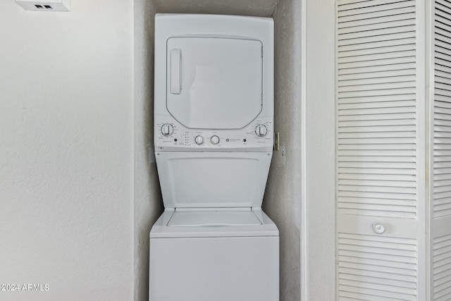 clothes washing area featuring stacked washer / drying machine