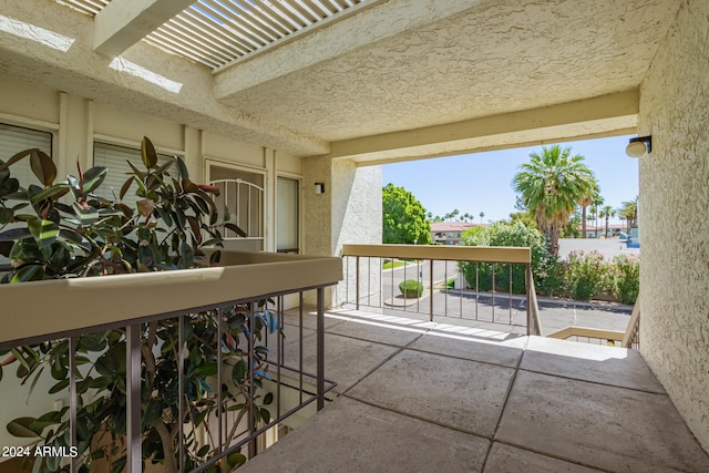 view of patio with a pergola and a balcony