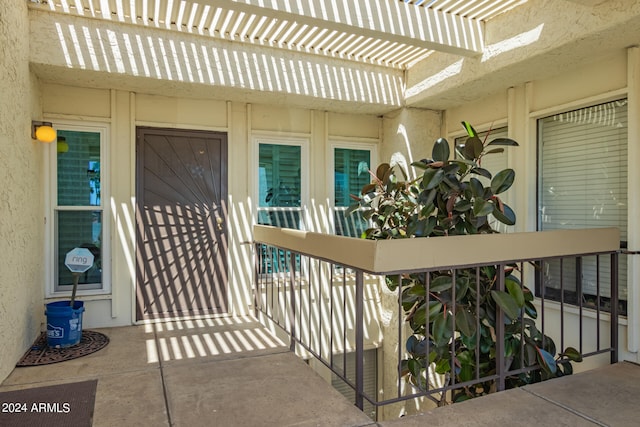 doorway to property featuring a pergola