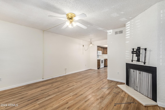 unfurnished living room featuring light hardwood / wood-style floors, a textured ceiling, and ceiling fan