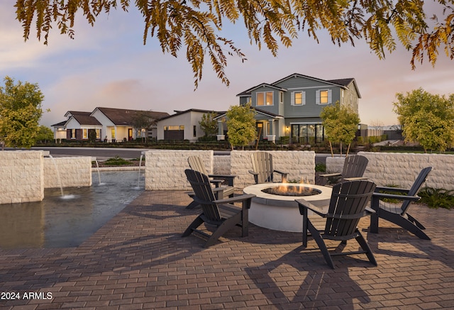 patio terrace at dusk featuring an outdoor fire pit