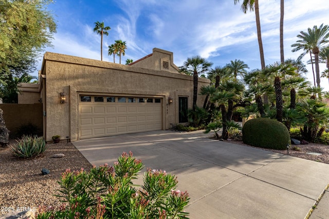 view of front facade featuring driveway, an attached garage, and stucco siding