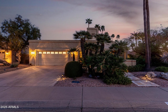 view of front of property featuring a garage, driveway, and stucco siding