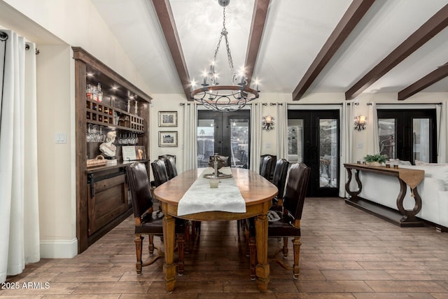 dining space with wood tiled floor, a chandelier, beam ceiling, and french doors