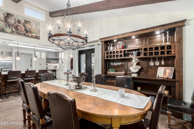 dining space featuring a chandelier, a high ceiling, and light wood-style floors