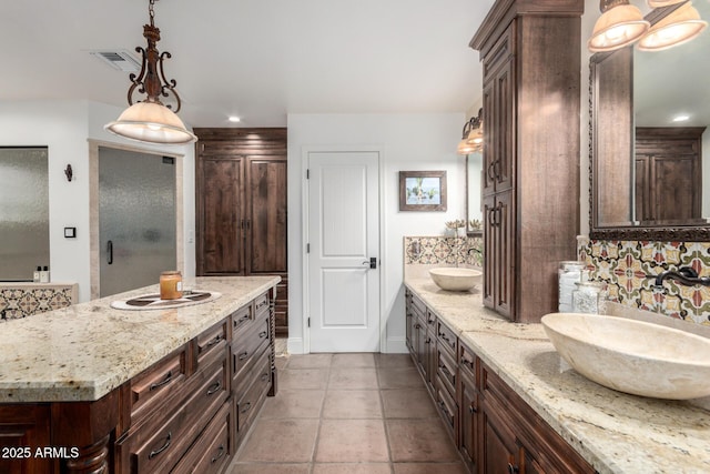 bathroom with visible vents, a sink, and double vanity