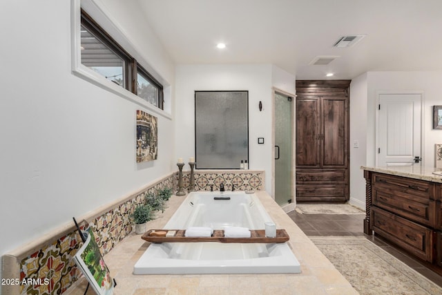 bathroom with a stall shower, visible vents, a bath, and vanity