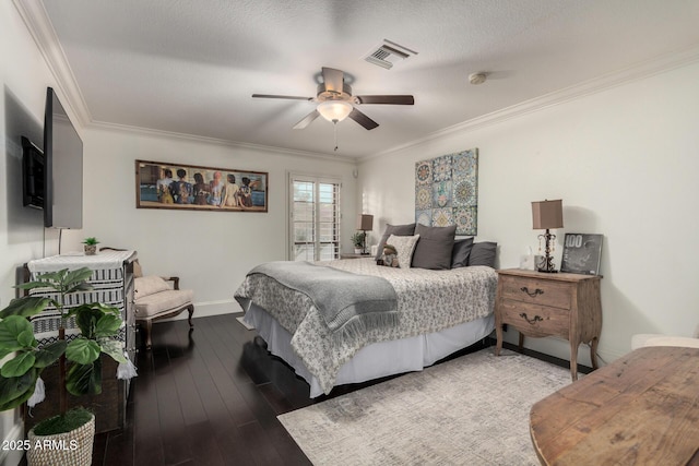 bedroom with visible vents, hardwood / wood-style floors, ornamental molding, ceiling fan, and baseboards