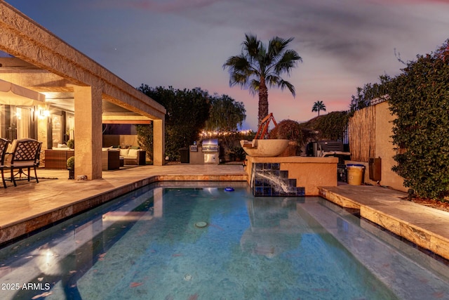 view of pool with exterior kitchen, a patio area, and an outdoor hangout area