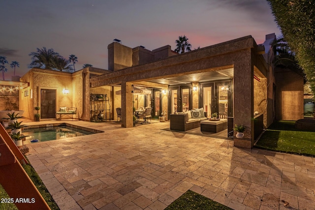 rear view of house with a patio area, a jacuzzi, and an outdoor hangout area