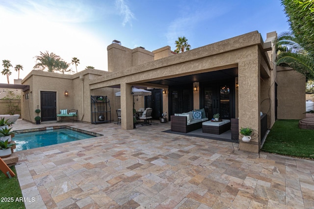 back of house with an outdoor hangout area, a patio area, and stucco siding