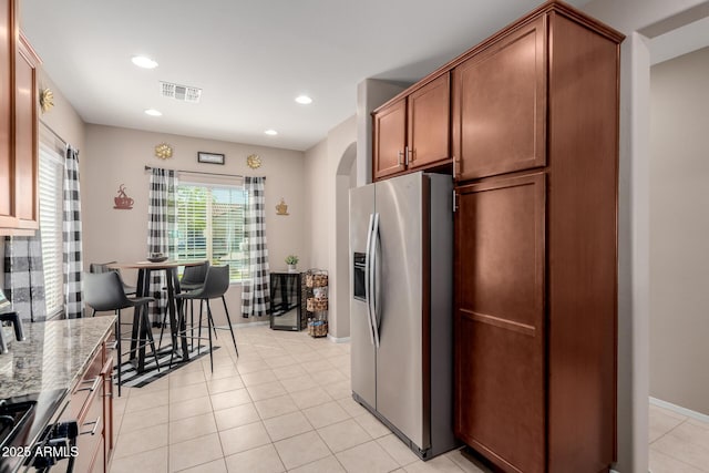 kitchen featuring visible vents, light stone countertops, recessed lighting, stainless steel refrigerator with ice dispenser, and light tile patterned flooring