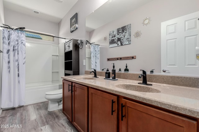 full bathroom featuring a sink, toilet, wood finished floors, and double vanity