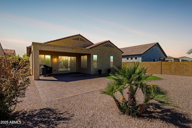 back of property featuring stucco siding, a patio, and fence