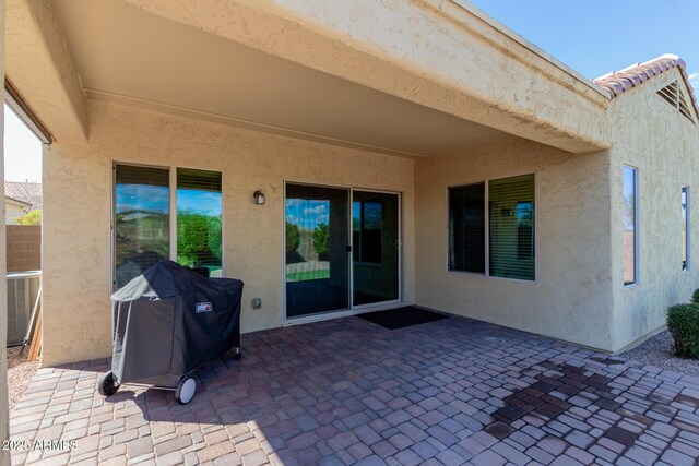 view of patio / terrace with cooling unit and a grill