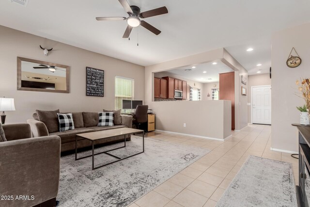 living area featuring baseboards, plenty of natural light, and light tile patterned flooring