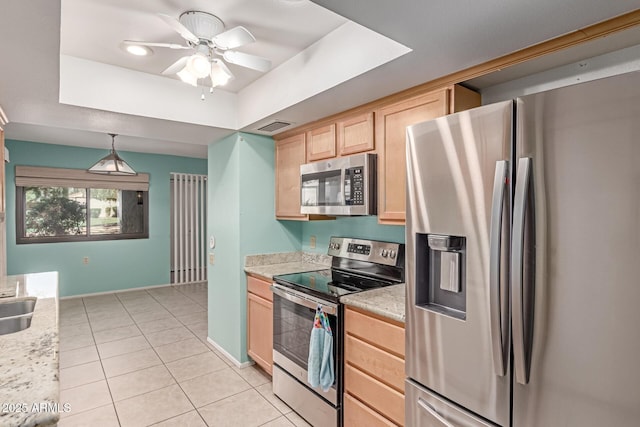 kitchen featuring visible vents, light brown cabinetry, a raised ceiling, light tile patterned floors, and stainless steel appliances