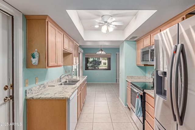 kitchen with ceiling fan, appliances with stainless steel finishes, a sink, light brown cabinets, and light tile patterned floors