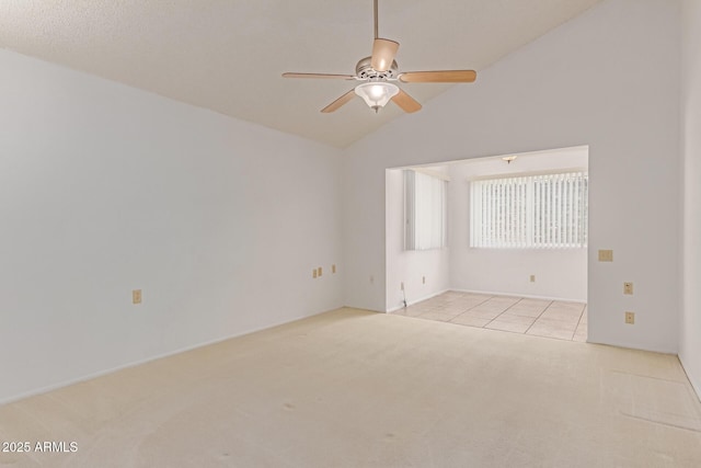 carpeted spare room with a ceiling fan and vaulted ceiling