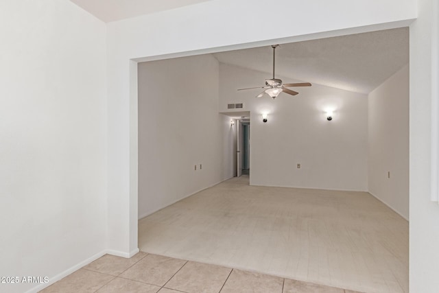 carpeted empty room with tile patterned flooring, a ceiling fan, lofted ceiling, and visible vents