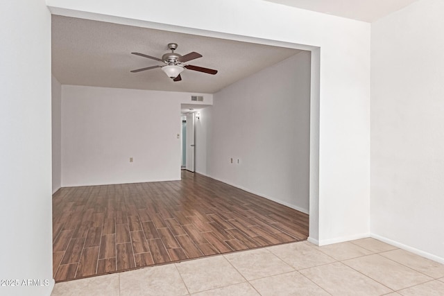 empty room featuring baseboards, ceiling fan, wood finished floors, and visible vents