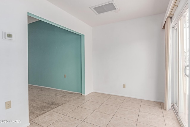 empty room featuring baseboards, light tile patterned flooring, and visible vents