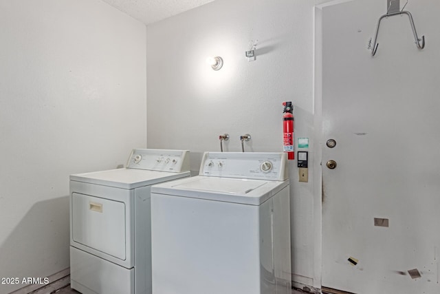 laundry room featuring laundry area, a textured ceiling, and washer and dryer
