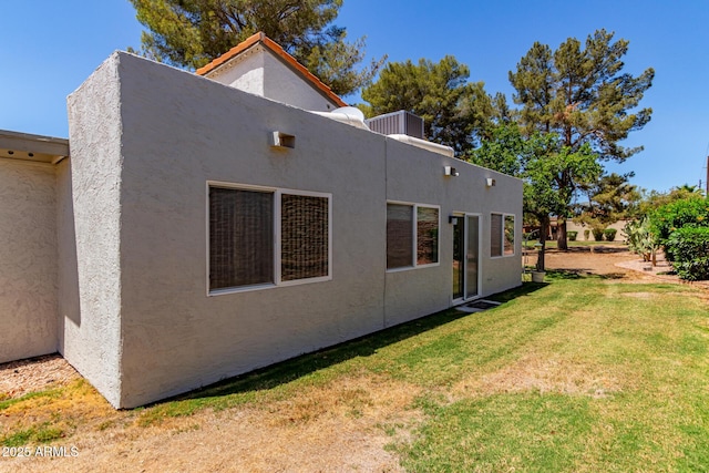 view of property exterior with stucco siding and a yard