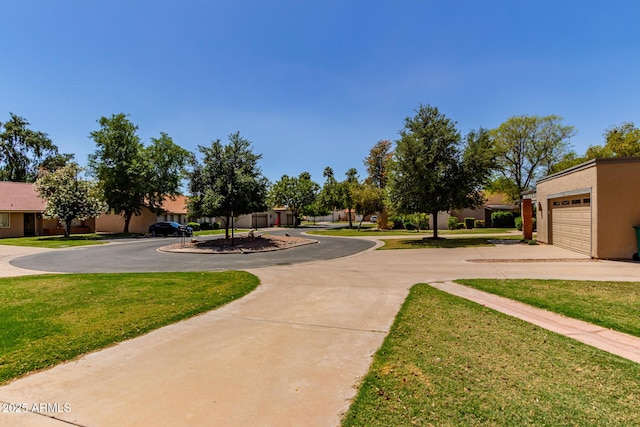 view of home's community with a yard and curved driveway