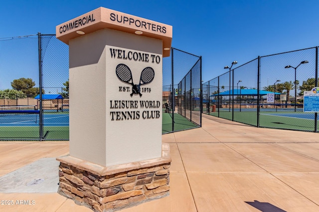 view of home's community with fence and a tennis court