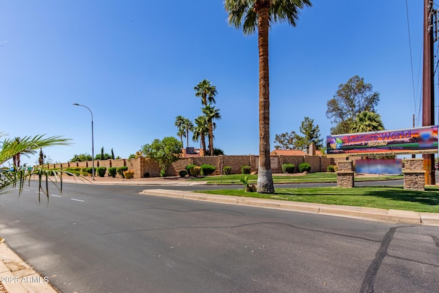view of road with street lighting, sidewalks, and curbs
