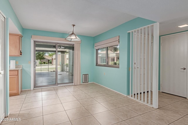 unfurnished dining area featuring baseboards and light tile patterned floors