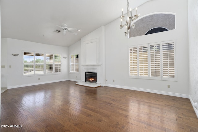 19102 N 91st St, Scottsdale, AZ 85255 - unfurnished living room featuring a ceiling fan, high vaulted ceiling, a large fireplace, dark wood-style flooring, and a chandelier