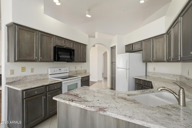 19102 N 91st St, Scottsdale, AZ 85255 - kitchen featuring white appliances, arched walkways, light stone counters, dark brown cabinets, and recessed lighting