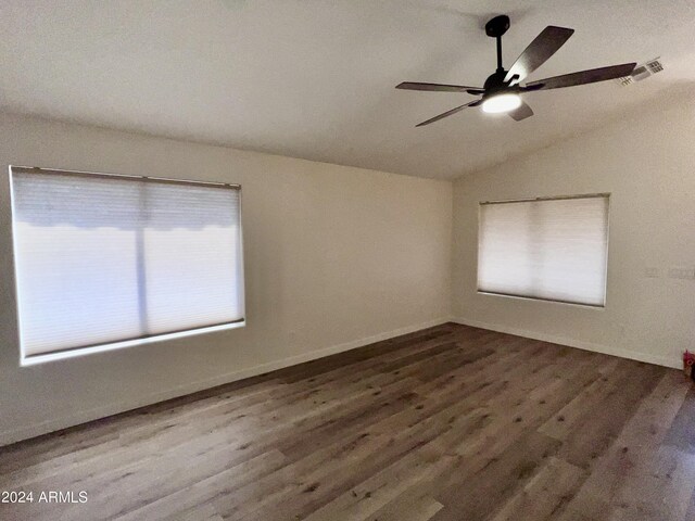 empty room featuring vaulted ceiling, wood-type flooring, ceiling fan, and a wealth of natural light