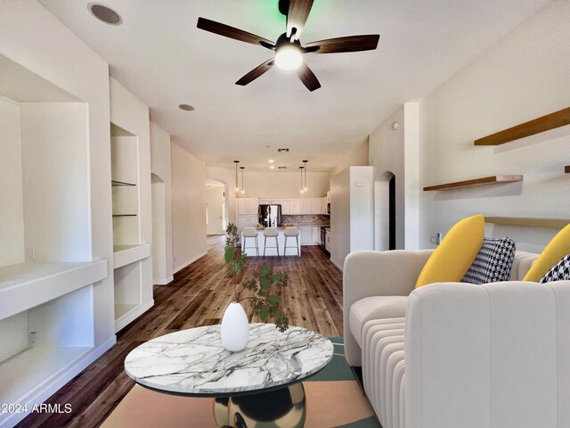 living room with ceiling fan and dark hardwood / wood-style flooring