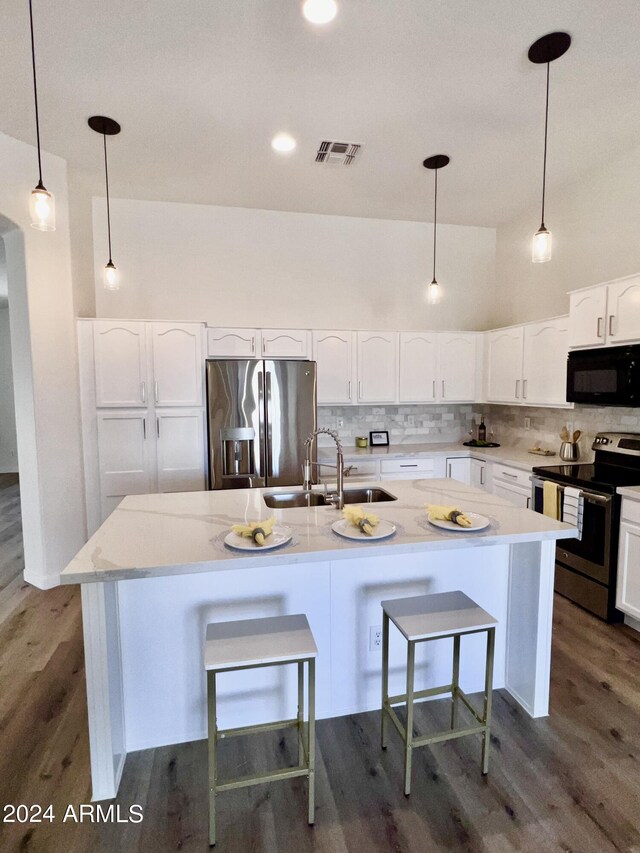 kitchen featuring an island with sink, stainless steel appliances, sink, and dark hardwood / wood-style floors