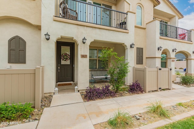 entrance to property with a balcony and stucco siding