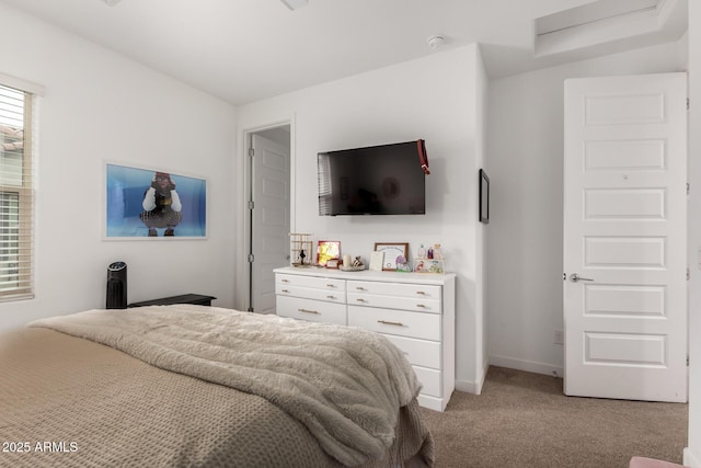 bedroom with light colored carpet, attic access, and baseboards